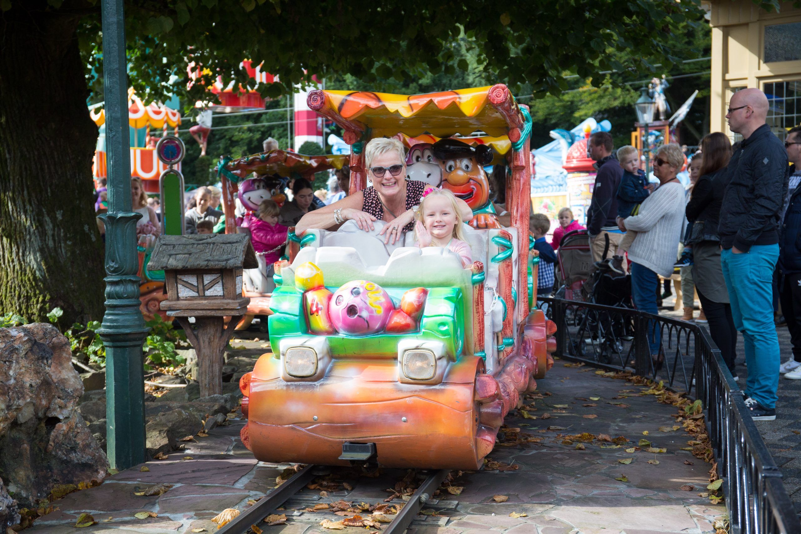 Grootouder en kleinkind lachen samen in het park.
