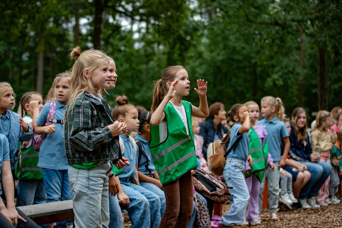 Een klas zingt en danst mee bij de show in de Julianatoren